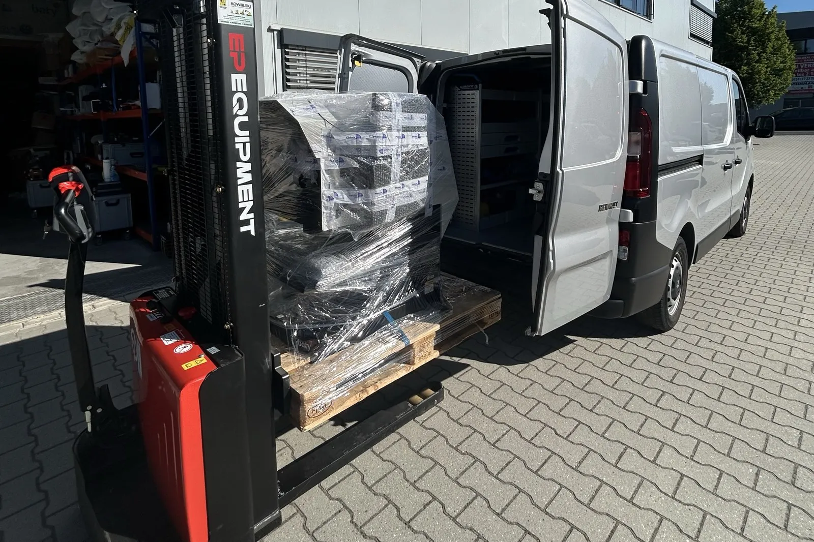 Palette mit verpackten Messmitteln wird per Hubwagen in den Transporter des Kalibrierdienstes geladen